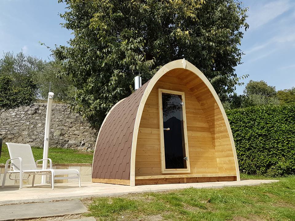 Kelo 300 sauna pod installed in a garden, showing the glazed front and covered entrance