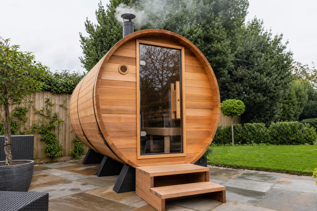 Traditional wood-fired outdoor barrel sauna with a chimney in a British garden