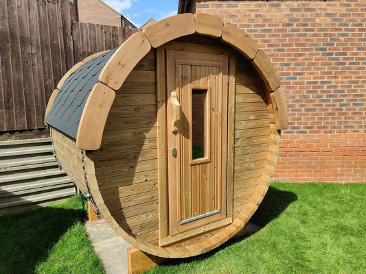 Holvi 170 thermowood barrel sauna in a garden, timber door with glazed window