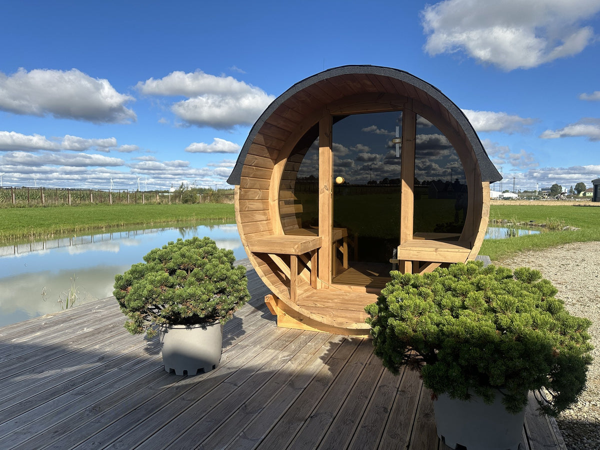 Holvi 300 thermowood barrel sauna with glass facade on waterside decking