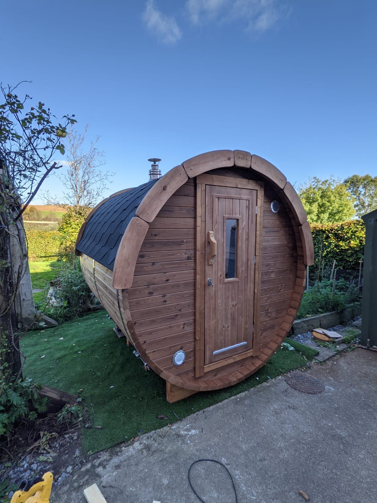 Holvi 300 Compact thermowood barrel sauna in a garden