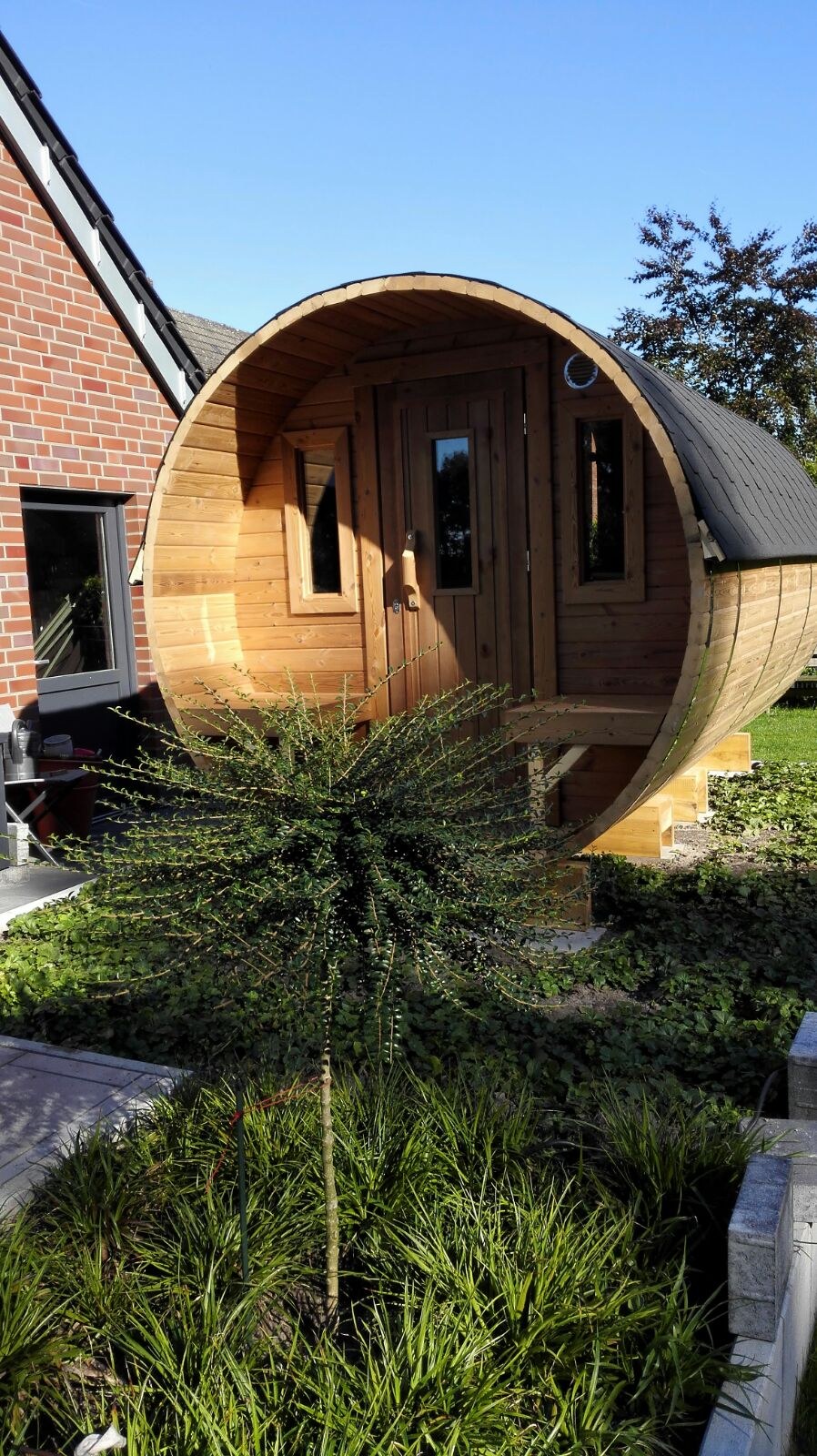 Holvi 450 thermowood barrel sauna beside a house