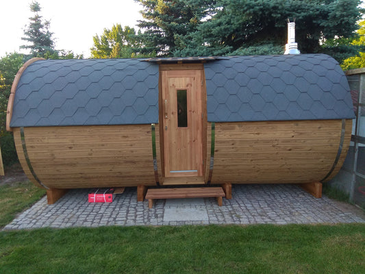 Holvi 480 Side barrel sauna in a garden, entrance door in the middle of the barrel
