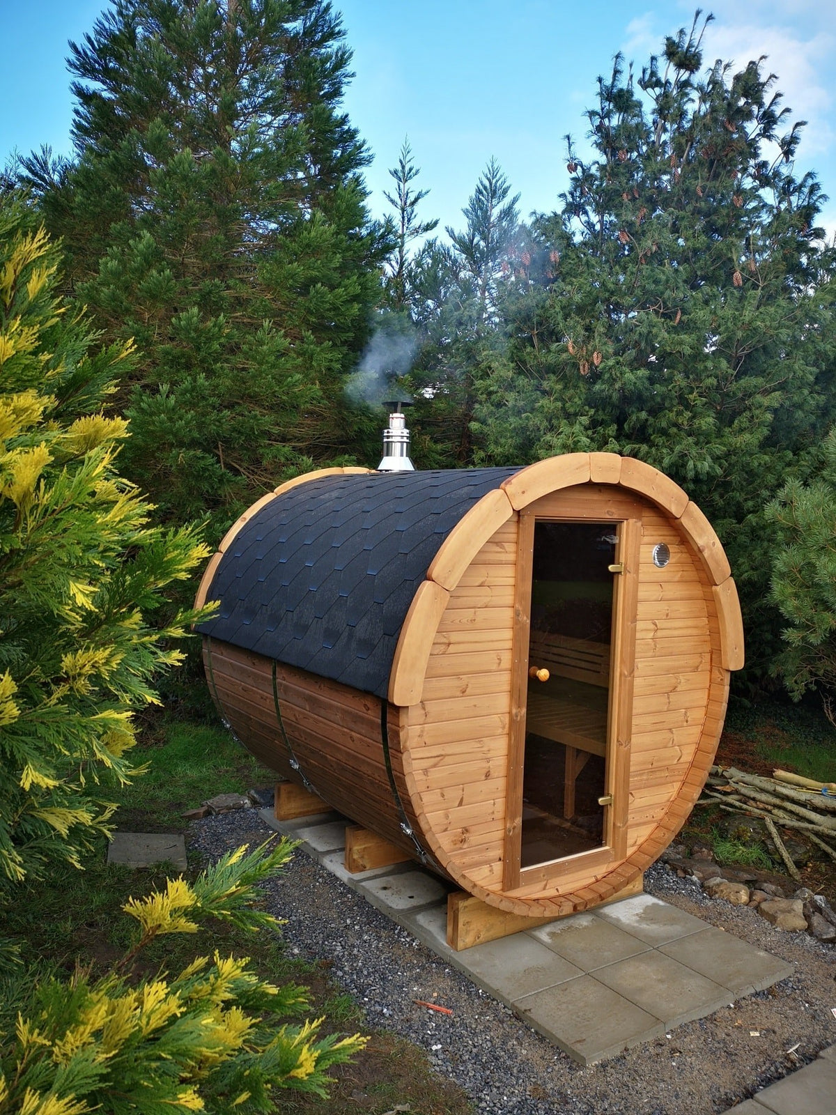 Holvi 240 with tinted glass door and black shingle roof in a garden