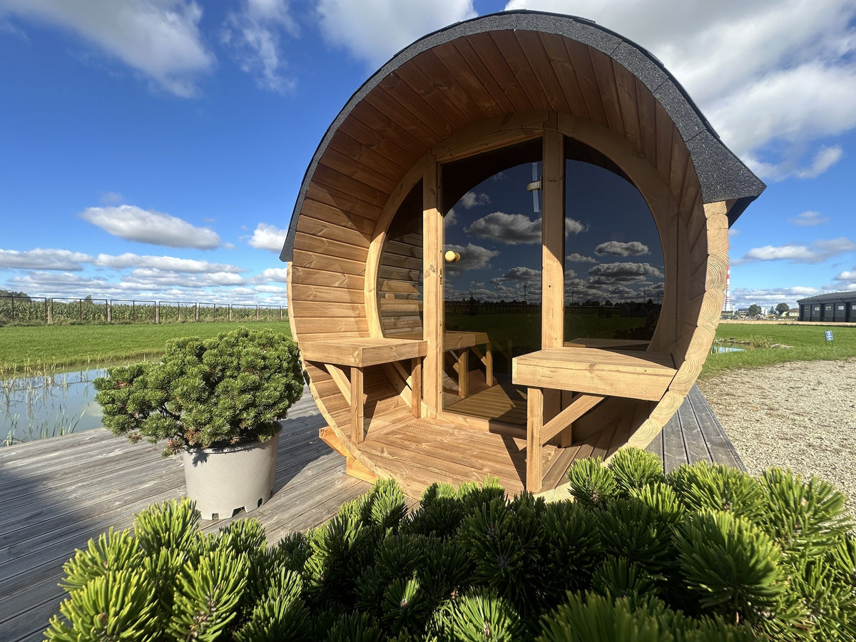 Holvi 300 barrel sauna seen from the front with its glazed facade and porch benches