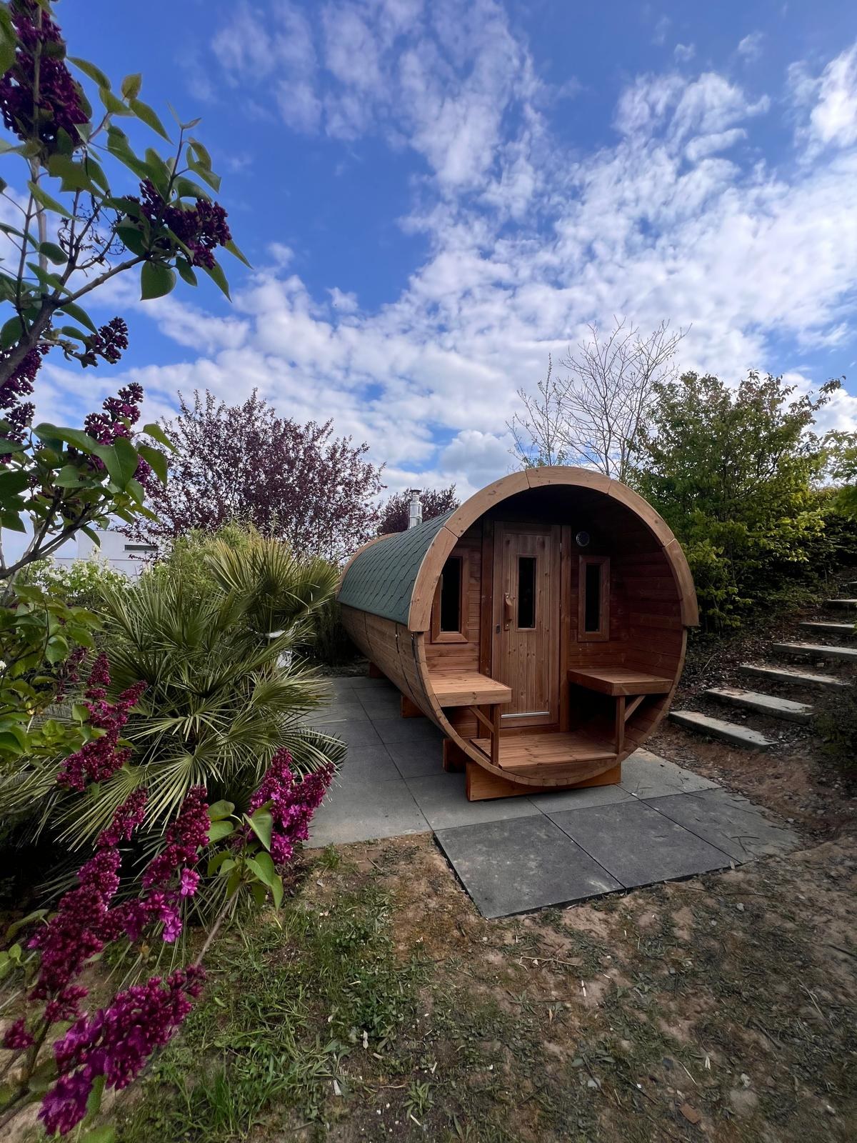 Holvi 480 thermowood barrel sauna in a planted garden