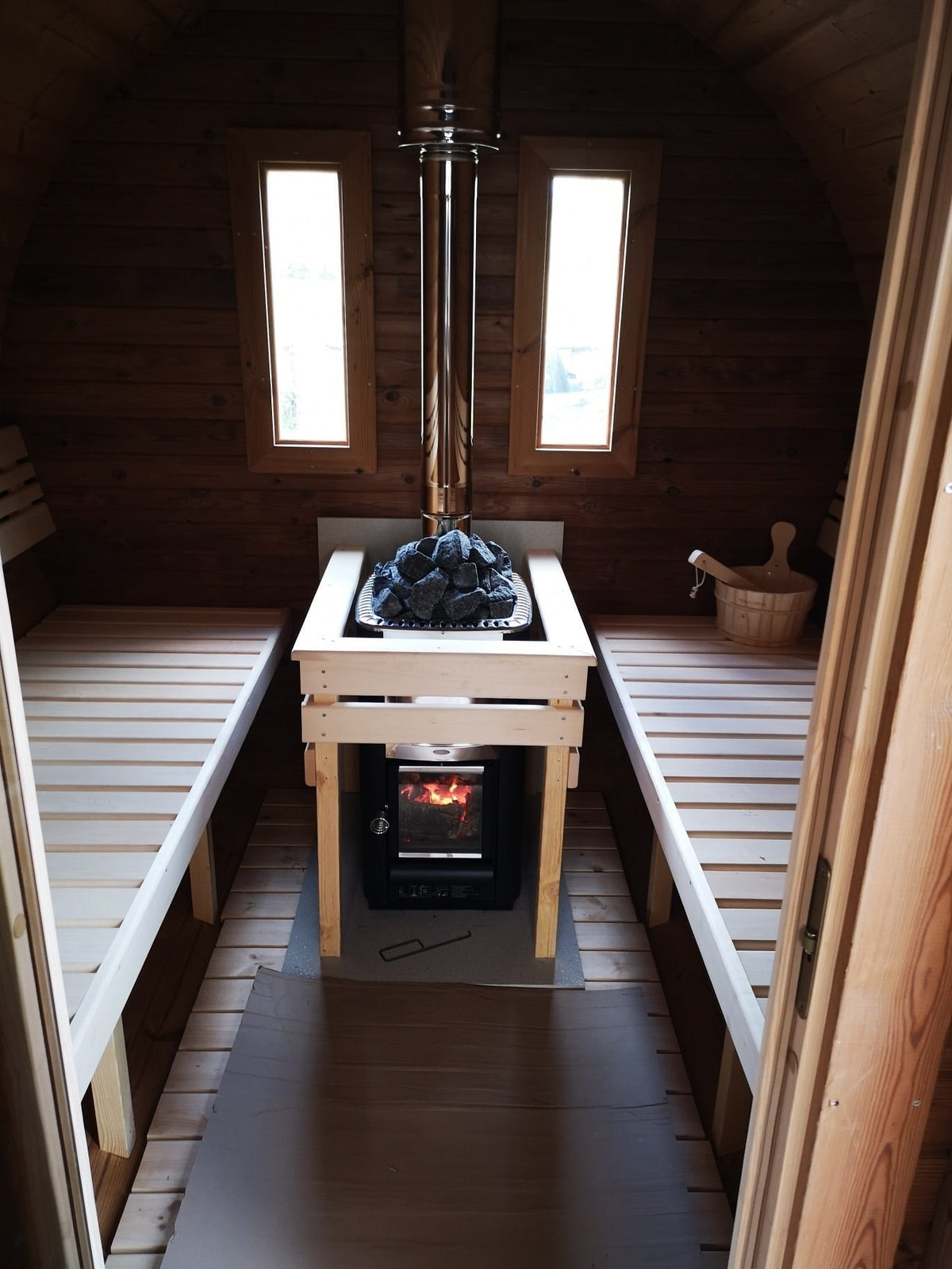 Holvi 480 hot room with the wood fired stove between the benches