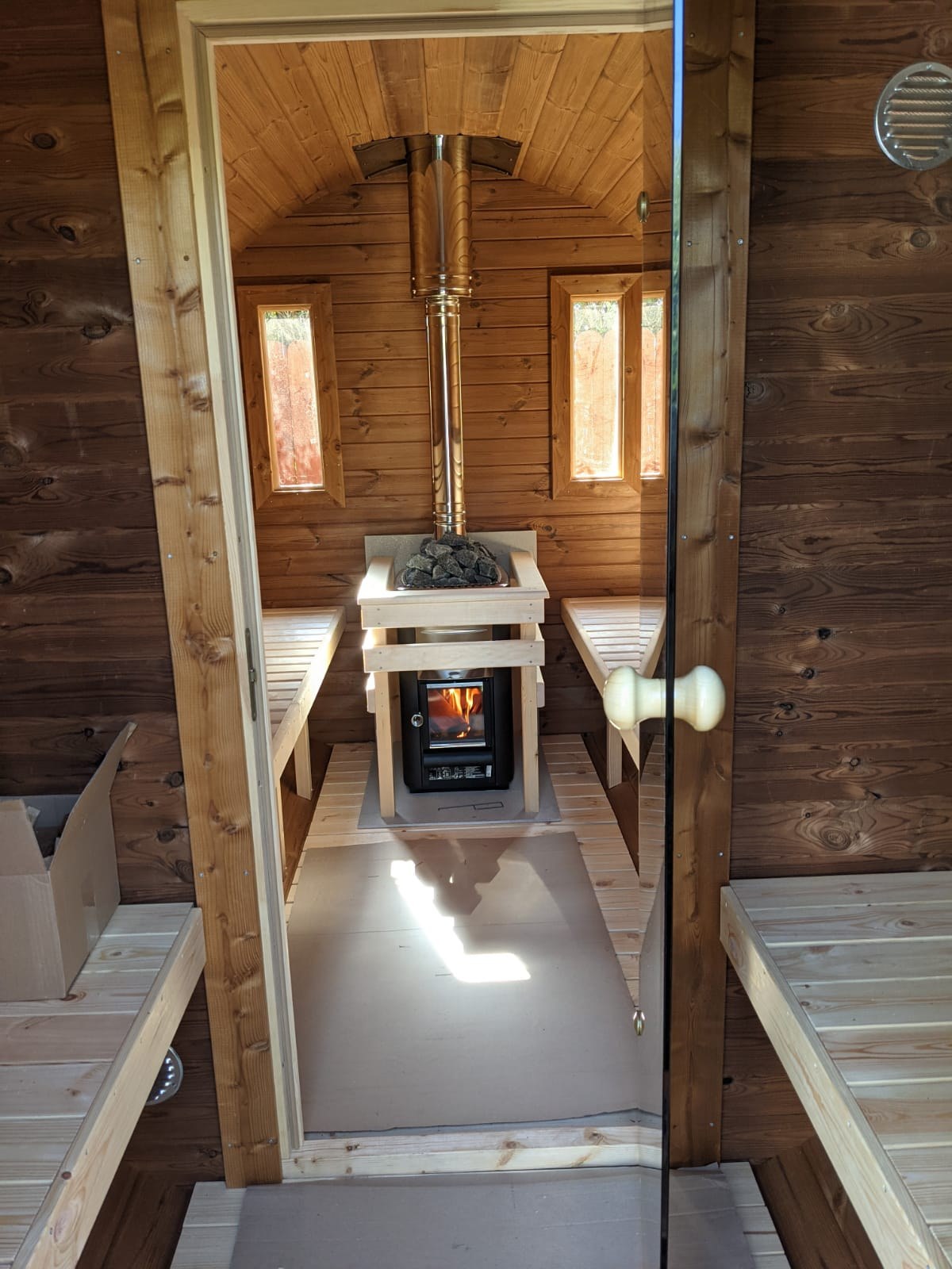 Looking from the changing room through the glass door to the wood fired stove