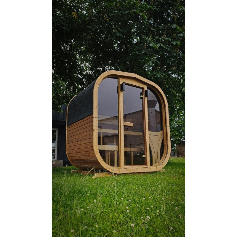 1.6m Cube Sauna installed on a garden lawn, glass front and shingle roof