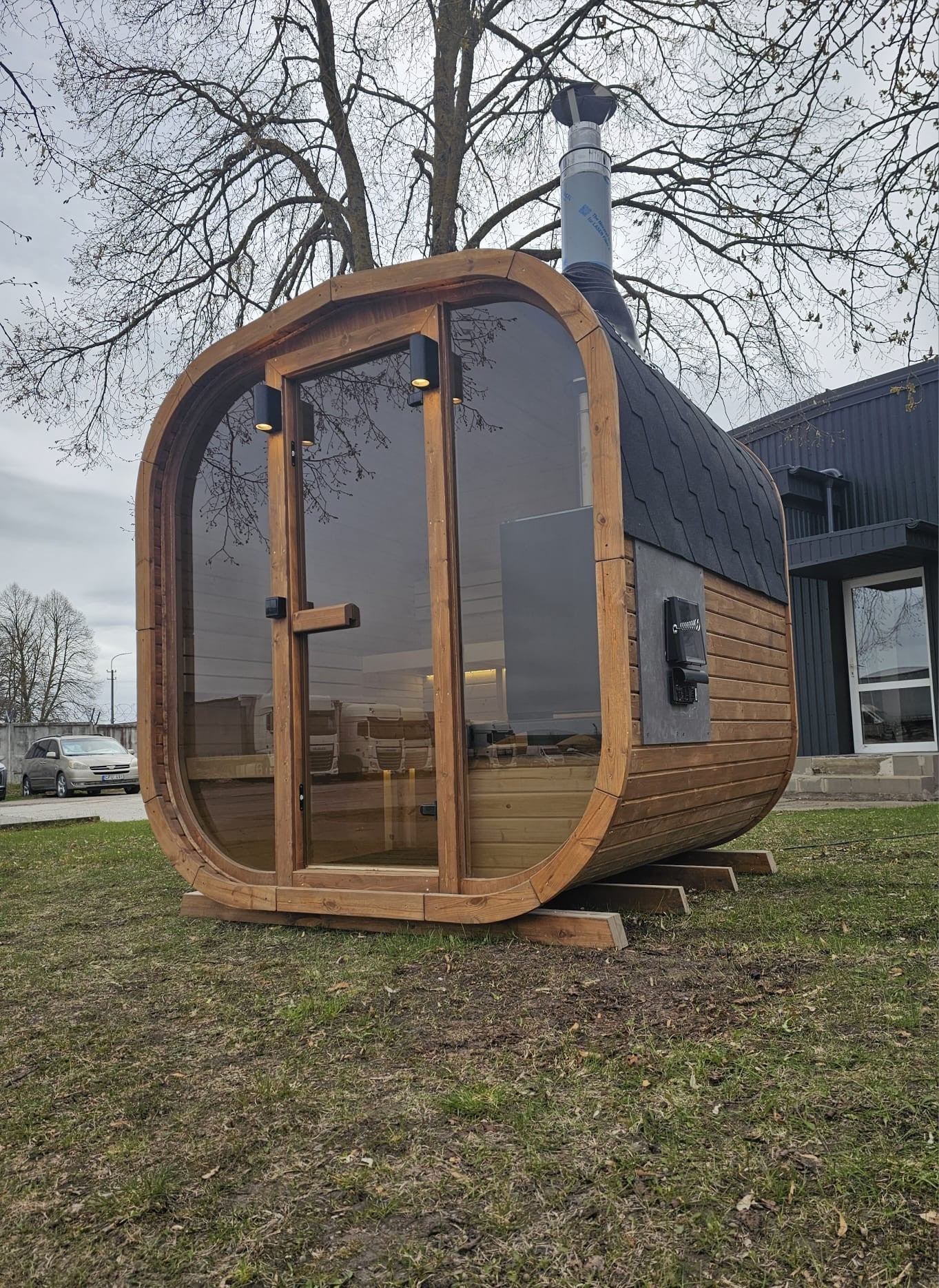 Cube Sauna 2m exterior at dusk showing warm interior lighting through the glass front