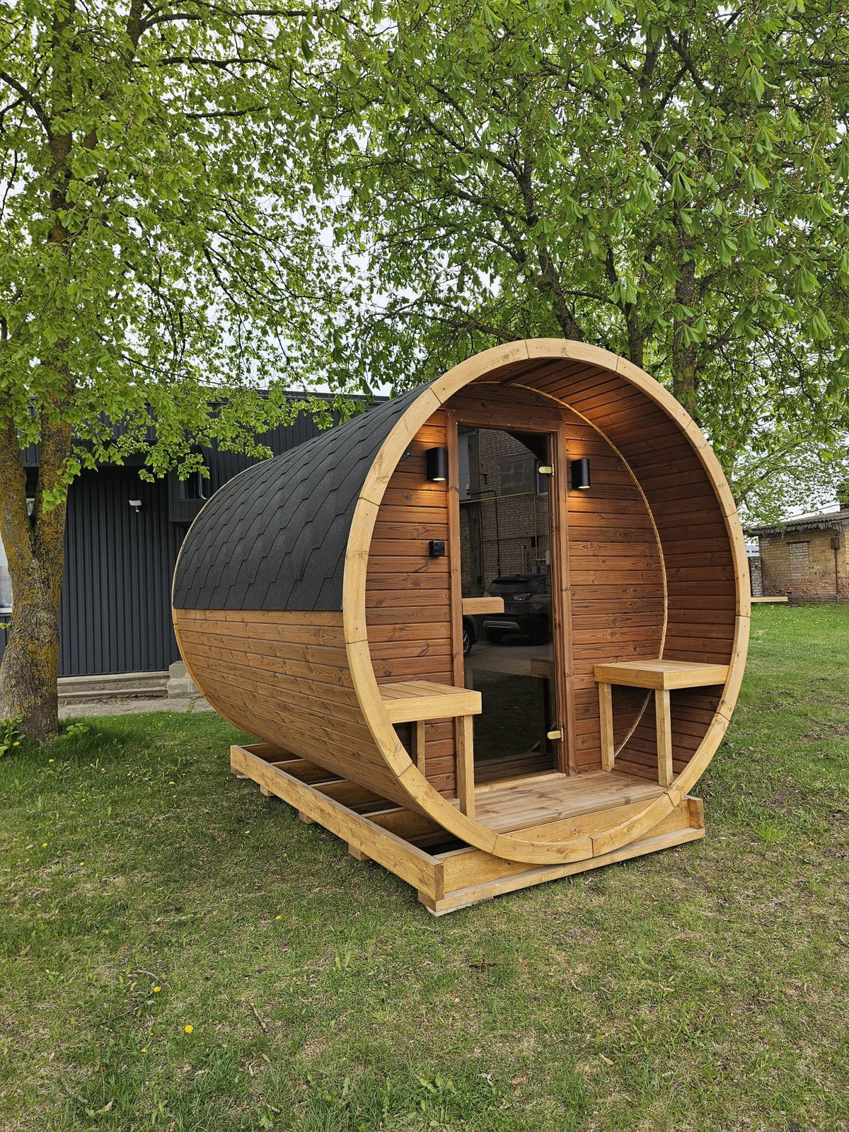 Vanne 3m thermowood barrel sauna side profile in a garden setting