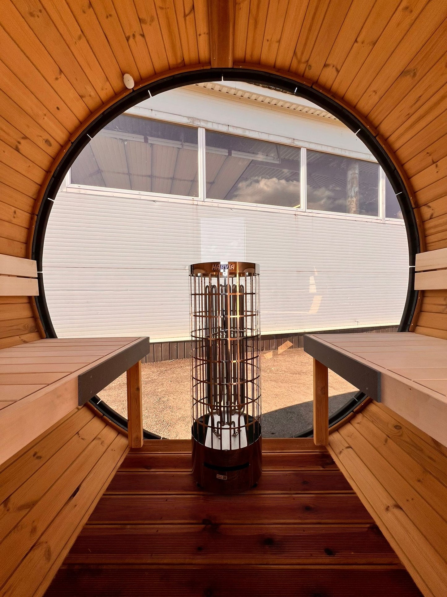 Hiili black barrel sauna interior with linden benches and under bench LED lighting