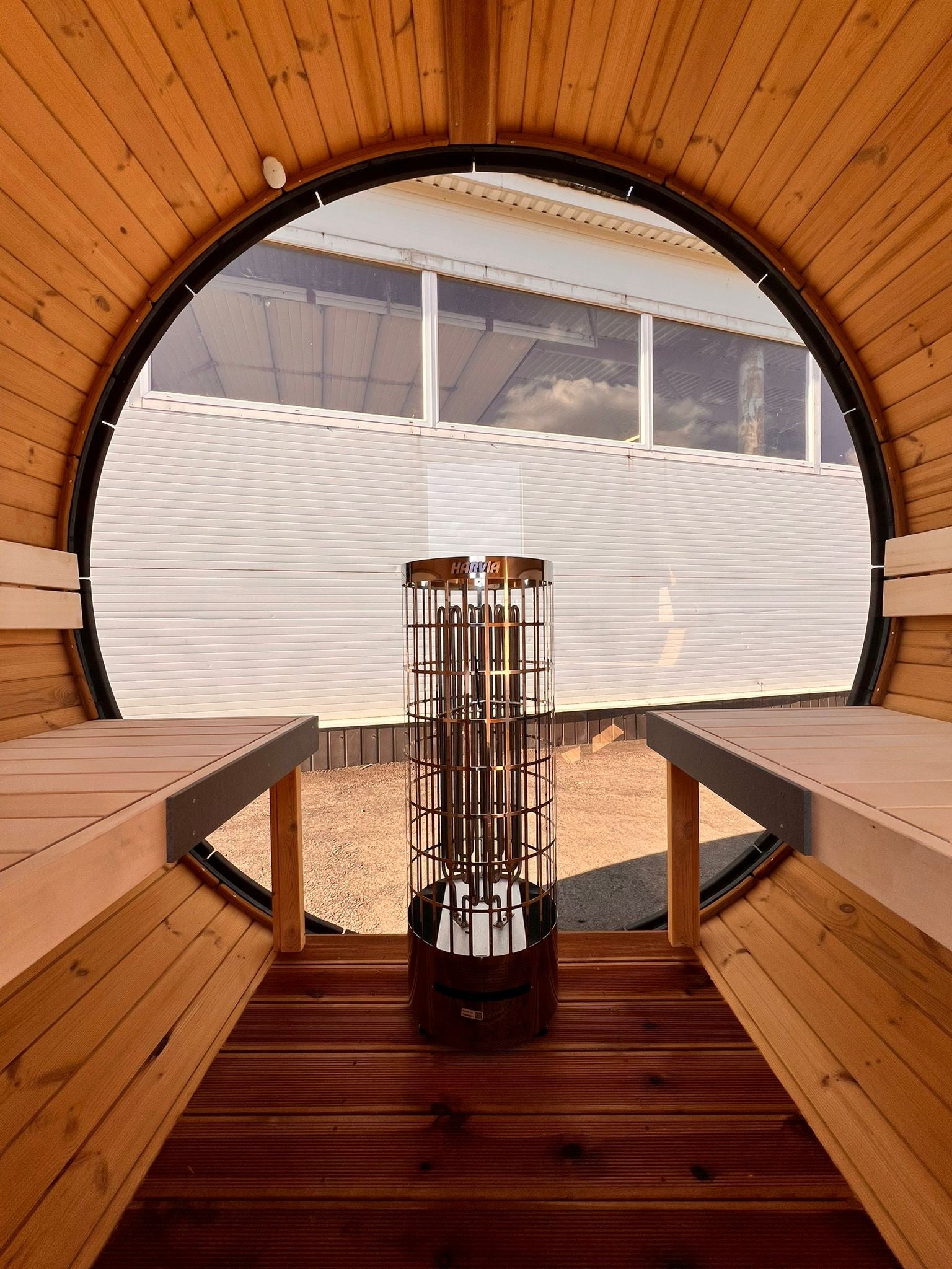 Hiili black barrel sauna interior with linden benches and under bench LED lighting