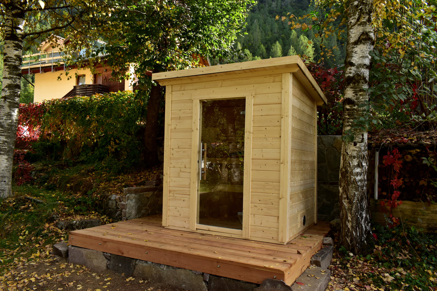 Steam & Oak Honka 180 sauna cabin installed on a timber deck in a hillside garden