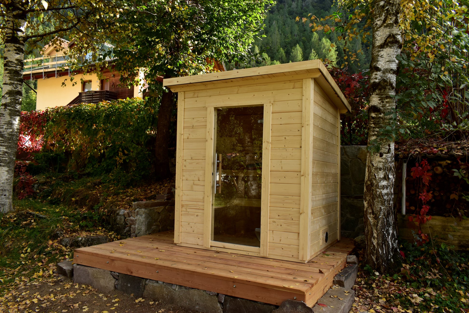 Steam & Oak Honka 180 sauna cabin installed on a timber deck in a hillside garden
