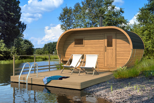 Steam & Oak Oval 240 garden sauna on a lakeside deck, showing the covered terrace end and timber door
