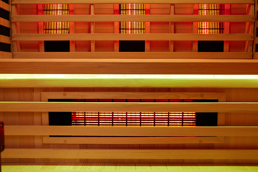 Infrared emitter panel mounted on the sauna wall behind the bench