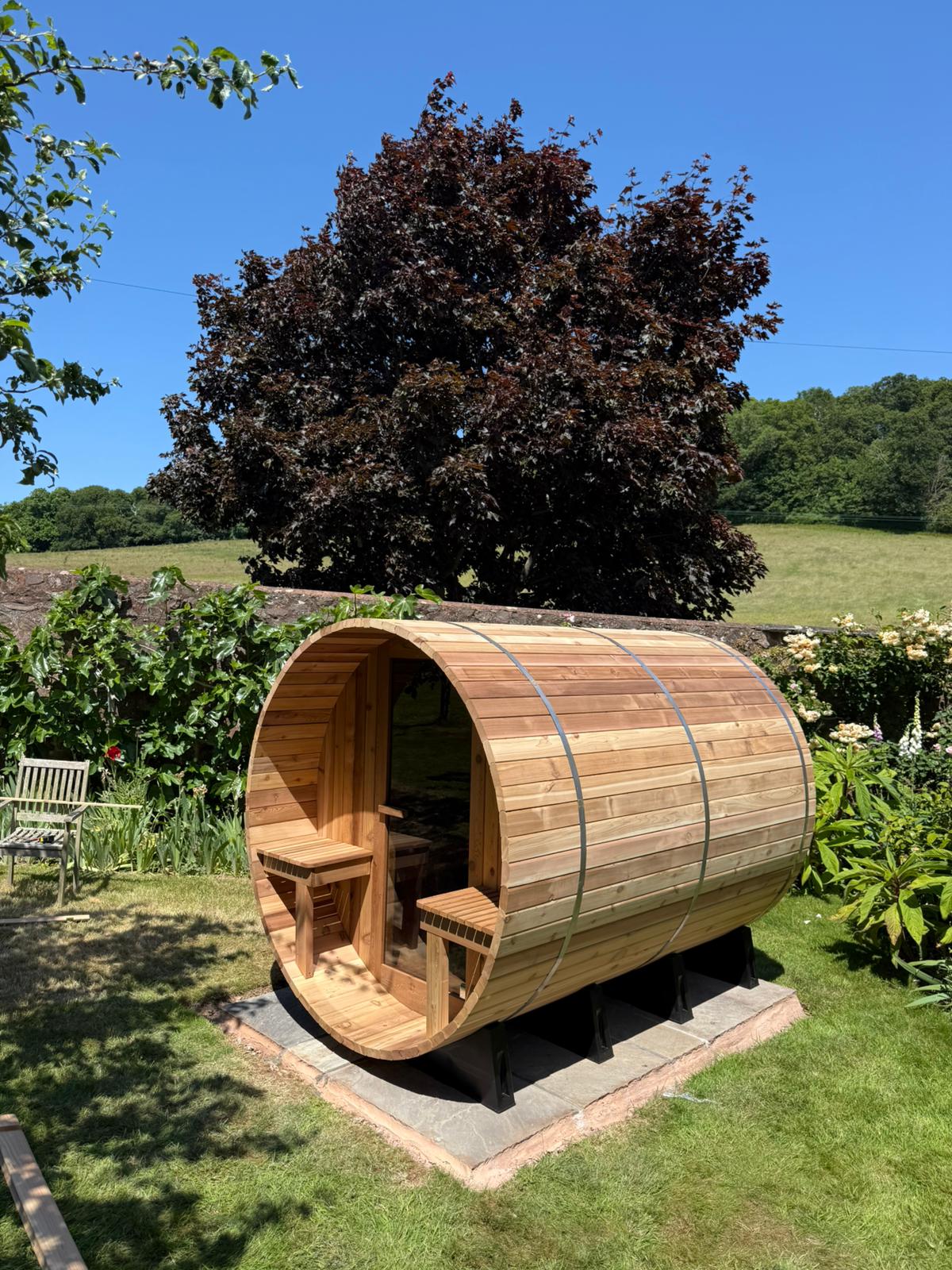 Barrel sauna with a covered porch seen from the front