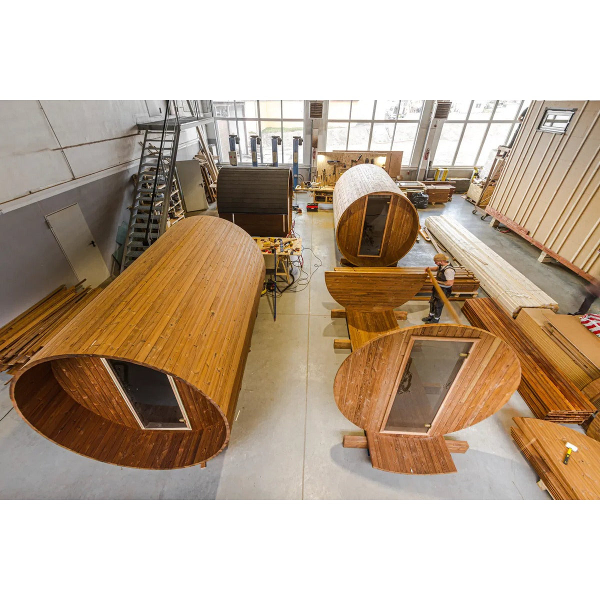 Factory production line image showing barrel sauna cabins in manufacture.