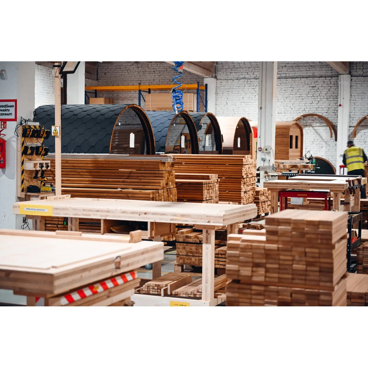 Workshop image showing multiple barrel sauna units in production.