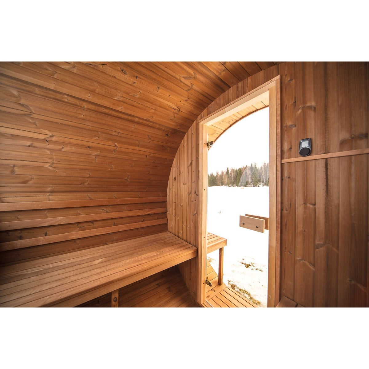 Interior bench seating inside the Hekla Barrel Sauna 250, view towards the door.