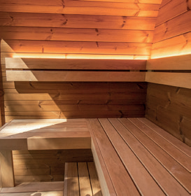Holl's Onyxia Cube outdoor sauna with mirrored glass facade reflecting sky in a field