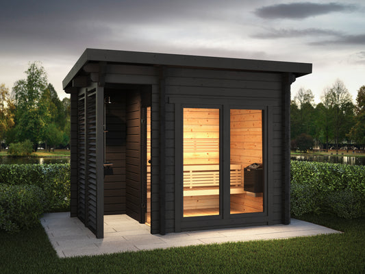 Steam & Oak Isle 300 log sauna at dusk with covered terrace, screened outdoor shower and lit sauna room