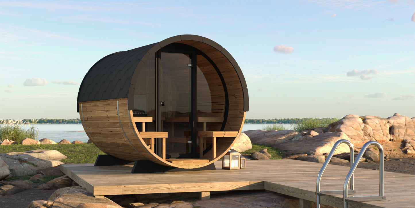 Steam & Oak Saaren 280 Panorama barrel sauna on a lakeside deck, thermowood with black shingle roof and full glass front