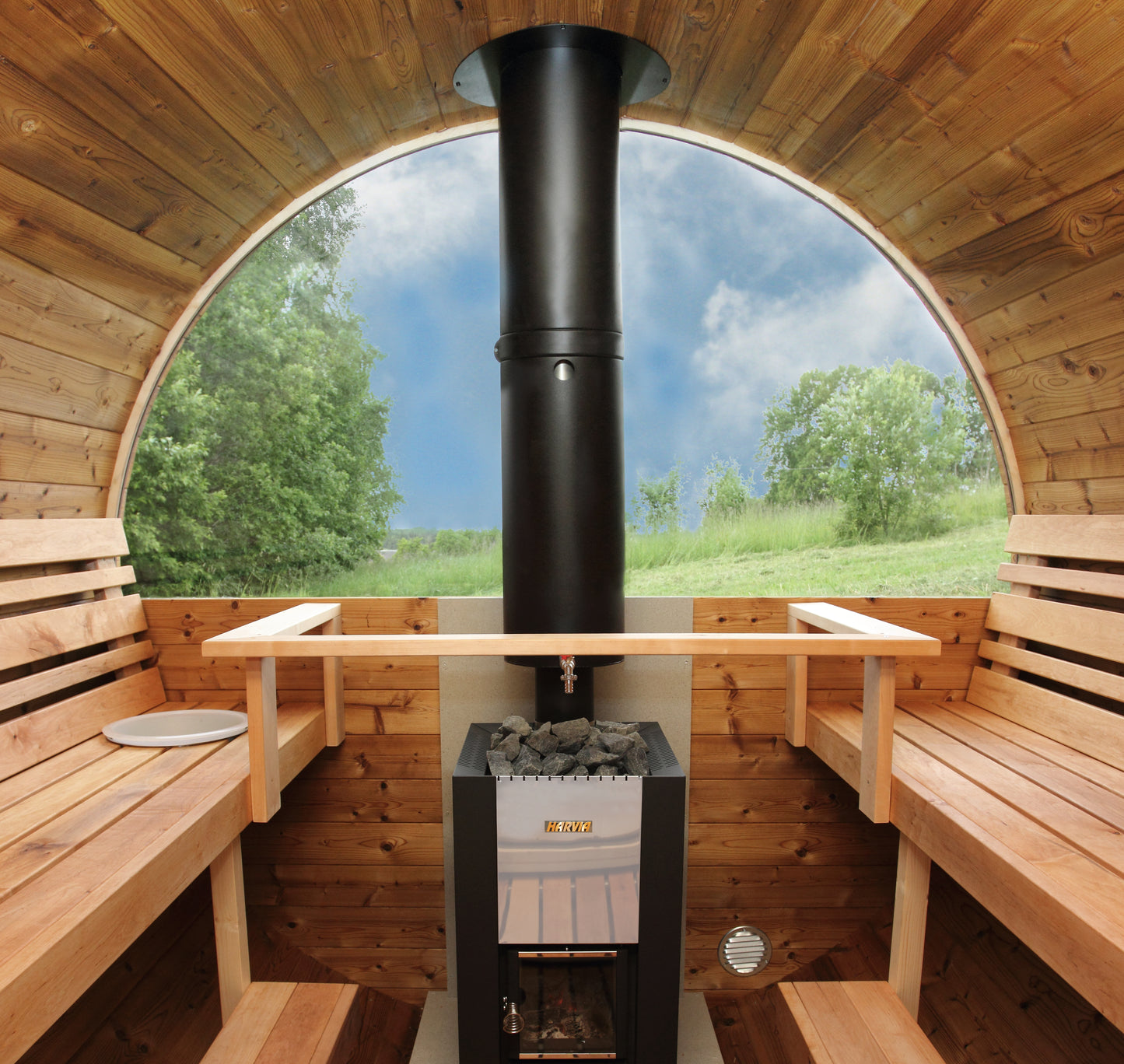 Inside the Saaren 400 Panorama looking out through the half-moon glass wall, wood-fired Harvia stove